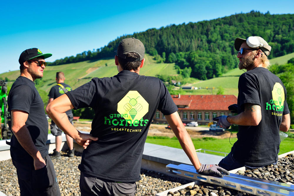 Zwei Monteure bei der gemeinsamen Installation einer Photovoltaikanlage